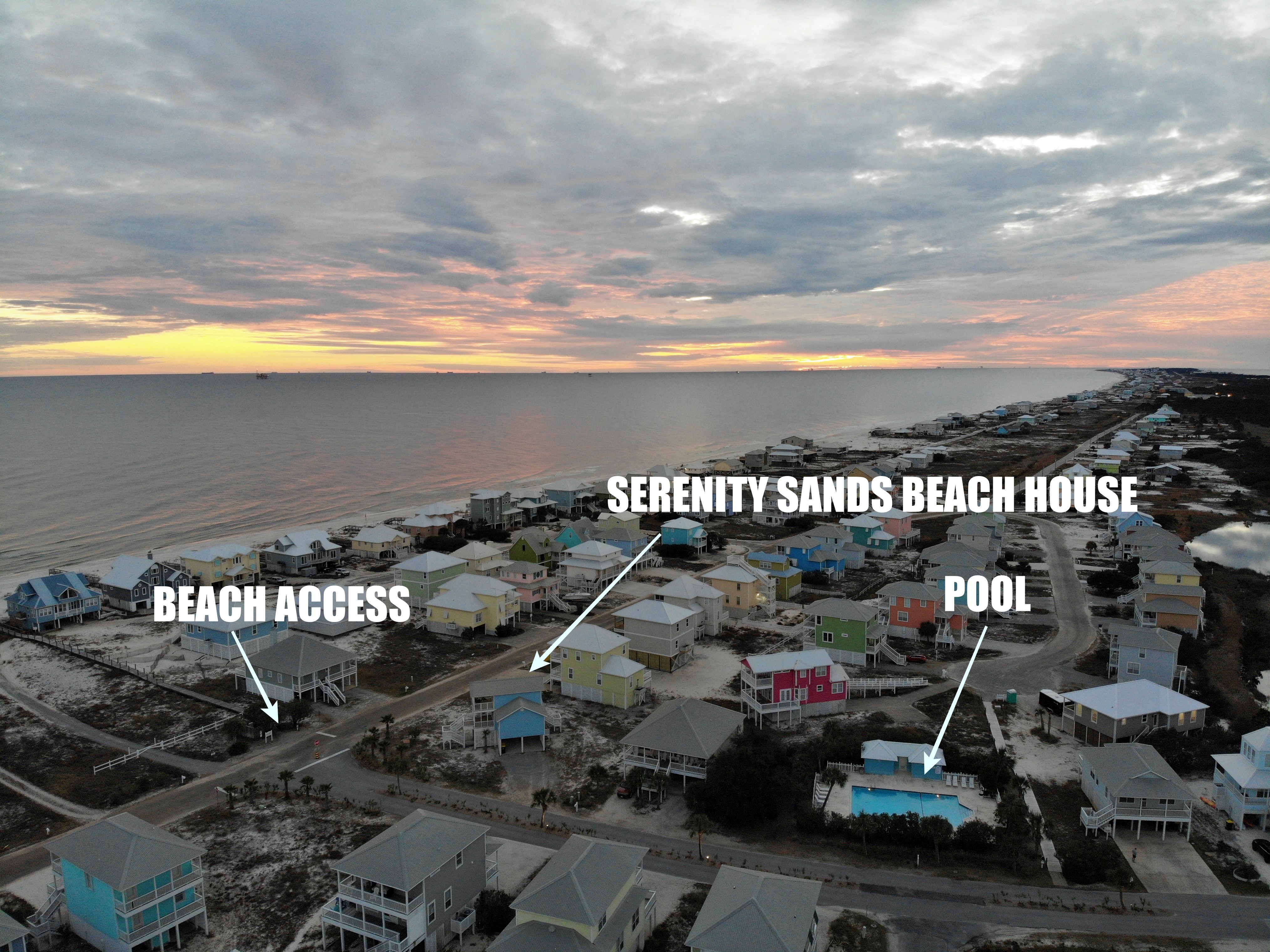 https://alabama-travel.s3.amazonaws.com/partners-uploads/photo/image/5edadf2f707f3b00071e252e/aerial view of sunset over Serenity Sands Beach House, beach boardwalk and pool.jpg